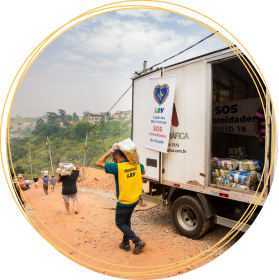 Arte com foto de caminhão da LBV, com voluntários descarregando as cestas de alimentos