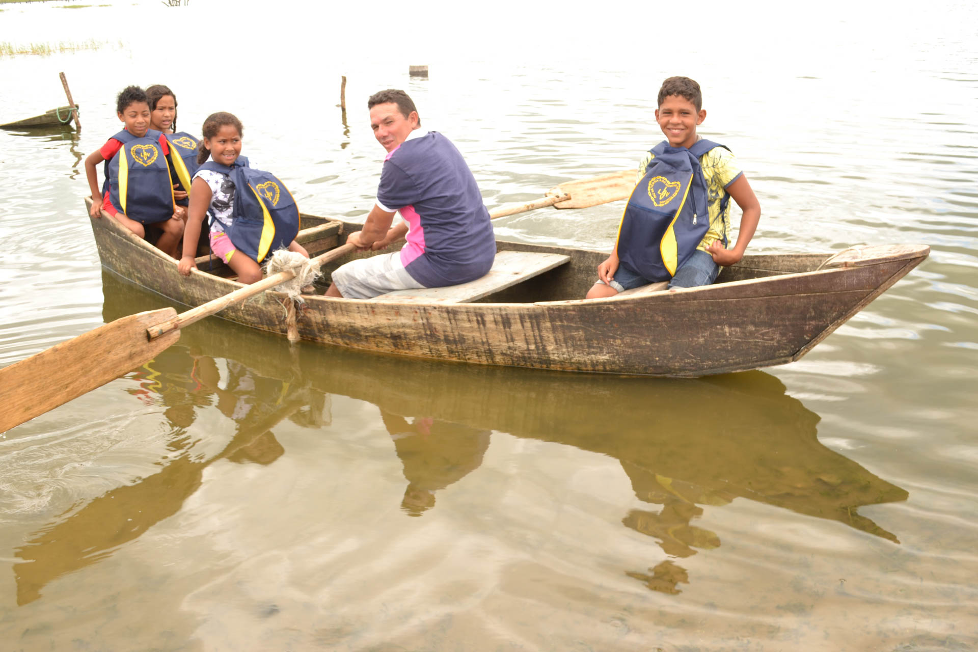 Macaíba, RN — Atendidos seguem de barco com o novo material escolar pedagógico. Entre os diversos itens na mochila, há estojo, lápis preto e de cor, canetas, apontador, borrachas, tesoura, tubos de cola, tinta guache, cadernos, mochila, régua, dicionário da língua portuguesa (com a nova ortografia) e de inglês.