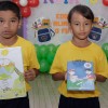 INHUMAS, GO — Crianças exibem, com orgulho, os itens pedagógicos da campanha Criança Nota 10 — Educar alimenta o futuro!. Além de ser um apoio importante para os estudos, os cadernos foram personalizados com desenhos feitos pelos próprios atendidos. A escolha se deu por intermédio de um concurso cultural. SAIBA MAIS