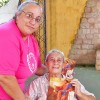Luque, Paraguay — La Hermana Legionaria Maria Eugenia presenta la revista ¡JESÚS ESTÁ LLEGANDO! a una abuela del Hogar para Ancianos San Francisco de Asís.