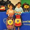 Sisters Cecibel and Gina smile as they hold their new backpacks at the Oliver St. School distribution