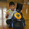 7-year-old Christopher opening his brand new backpack filled with materials from the LGW