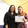 La profesora Vanina Rosa entrega el diploma a una alumna del curso de Cuidador de Adultos Mayores.