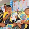 Belo Horizonte, MG — Os irmãos Isac, 10, e Samuel, 6, recebem com satisfação o kit de material pedagógico e exibem com alegria os itens que vieram dentro da mochila.
