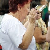 Peregrina traz fotos de seus entes queridos para receberem as forças do Templo da Boa Vontade

