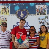 Fortaleza, CE — A LBV entregou, na capital cearense, mais de 41 toneladas de alimentos não perecíveis, em forma de cestas, por intermédio da campanha Natal Permanente da LBV — Jesus, o Pão Nosso de cada dia!. Beneficiada pela ação, a jovem Ana Clara, de 14 anos, destacou: “Aqui minha família tem o apoio, a mão amiga, não apenas a cesta de alimentos. Graças à LBV e aos colaboradores, eu terei um Natal feliz. Agradeço de coração aqueles que tiram um pouquinho do seu tempo para ajudar aqueles que mais precisam. Somos gratos!”. Na foto, a atendida está ao lado dos pais, a sra. Ana Rita da Silva Rodrigues e o sr. Francine.