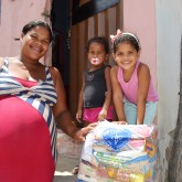 Pedra, PE — A senhora Josivania Pereira da Silva, ao lado de suas filhas Sara da Silva, 2, e Sandy da Silva, 5, leva com satisfação a sua cesta de alimentos para casa.
