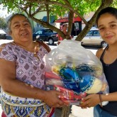 São Sebastião do Paraiso, MG — Ao lado da mãe, a jovem Nicole irradia felicidade por receber a cesta de alimentos da Legião da Boa Vontade, proveniente da campanha Natal Permanente da LBV — Jesus, o Pão Nosso de cada dia!.