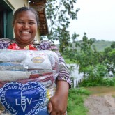 Jordânia, MG — A sra. Thaynan Gama mora no distrito de Estrela (a 15 quilômetros de Jordânia) e, em seu semblante, notamos a alegria em receber a cesta de alimentos da LBV. Para se ter uma ideia do quanto a Caravana da Boa Vontade percorreu Minas Gerais, observe a paisagem: a outra margem do rio, ao fundo na fotografia, já é o Estado da Bahia. É a LBV indo longe para ajudar os que mais precisam! =D
