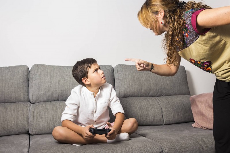 A menina com portátil joga o conceito dos jogos do vício do jogo